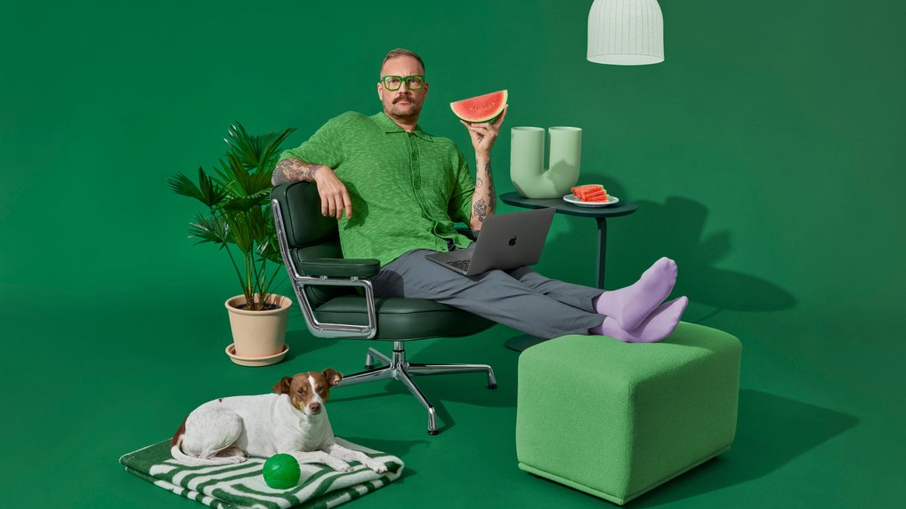 Man sitting in a chair, with a dog lying next to him on the floor